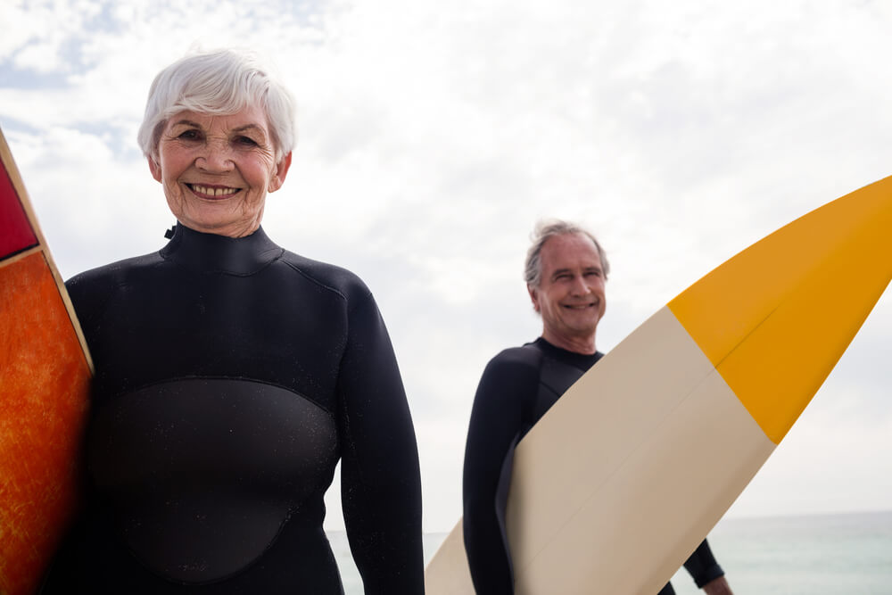 Man and woman with surfboards at the beach